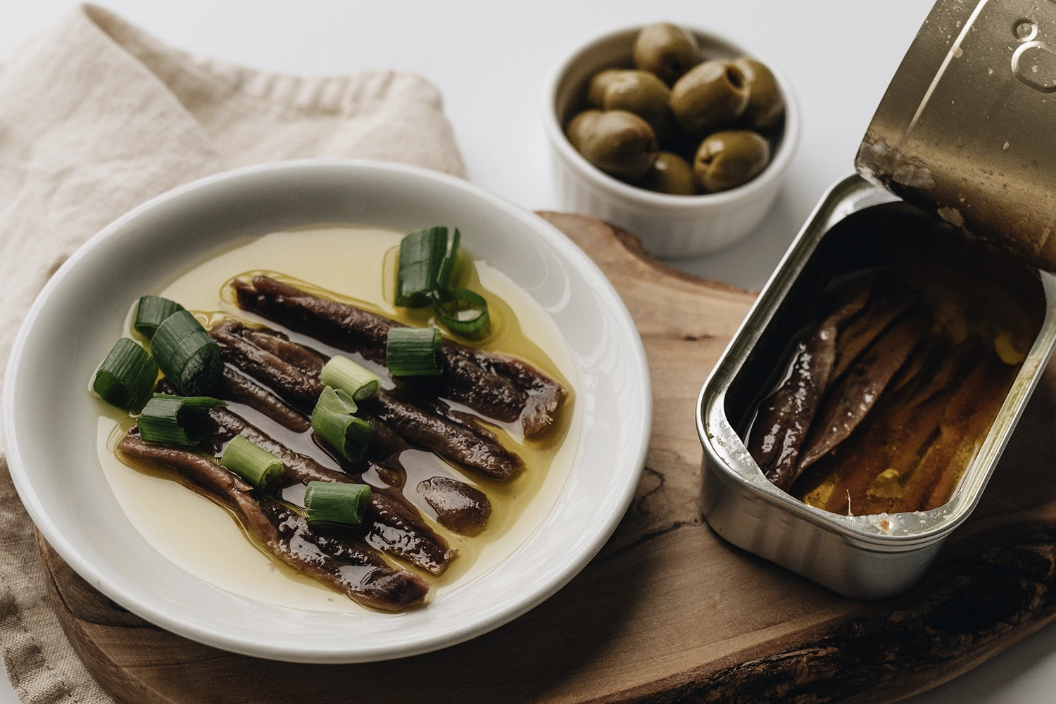 anchovies in olive oil on a plate and in a tin